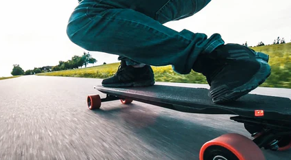 A man riding an electric skateboard on a road