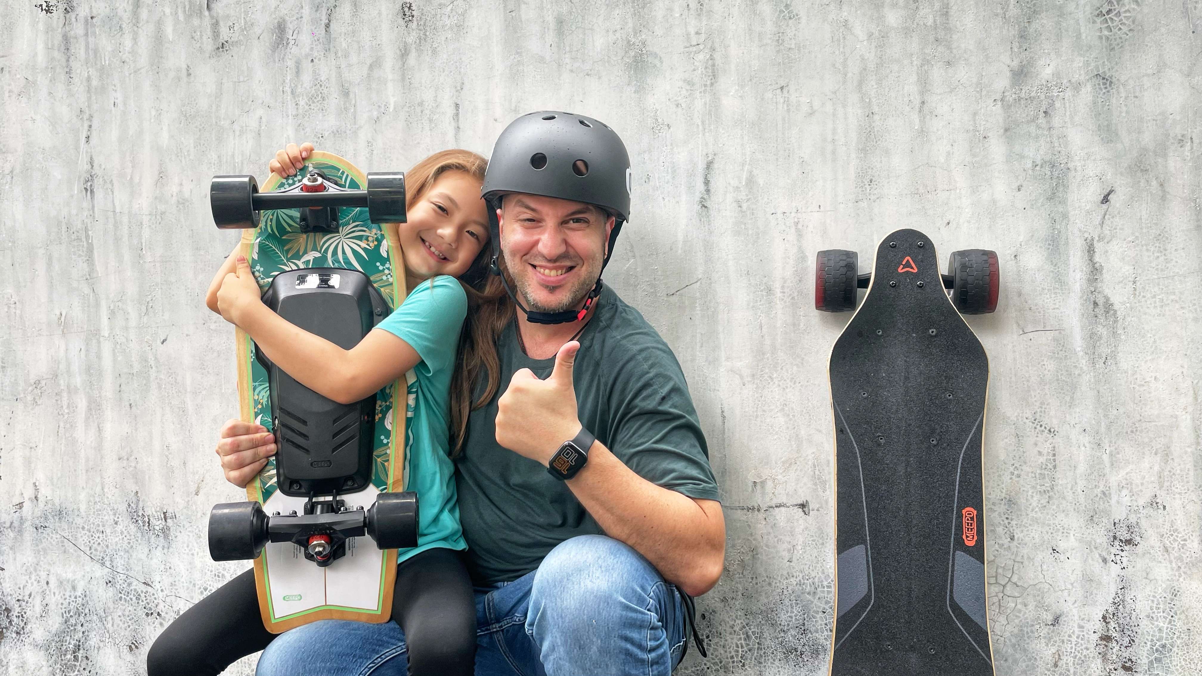 A woman standing on a hilltop with an electric skateboard