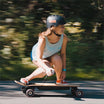 Woman carving on Meepo Flow electric skateboard, showcasing speed and style