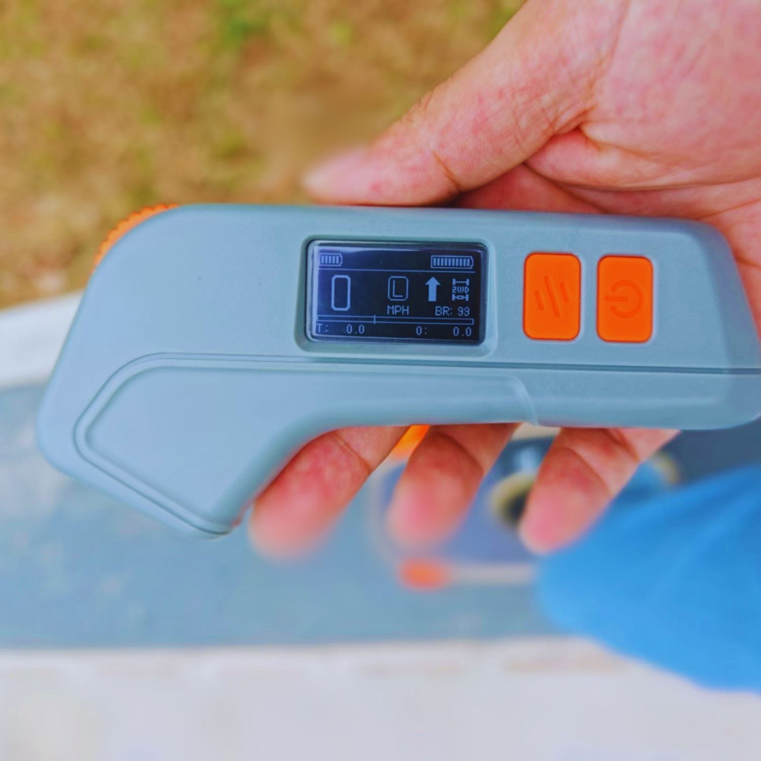 Close-up of Meepo Edge skateboard remote with display and buttons in a hand.