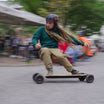 Rider maneuvering Meepo Hurricane Bamboo skateboard at event, highlighting its performance.