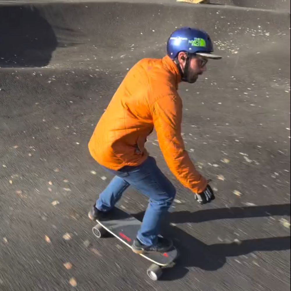 Rider maneuvering the Meepo Atom electric skateboard on pavement.