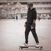 Rider on Meepo skateboard in city, showcasing urban mobility and safety gear.