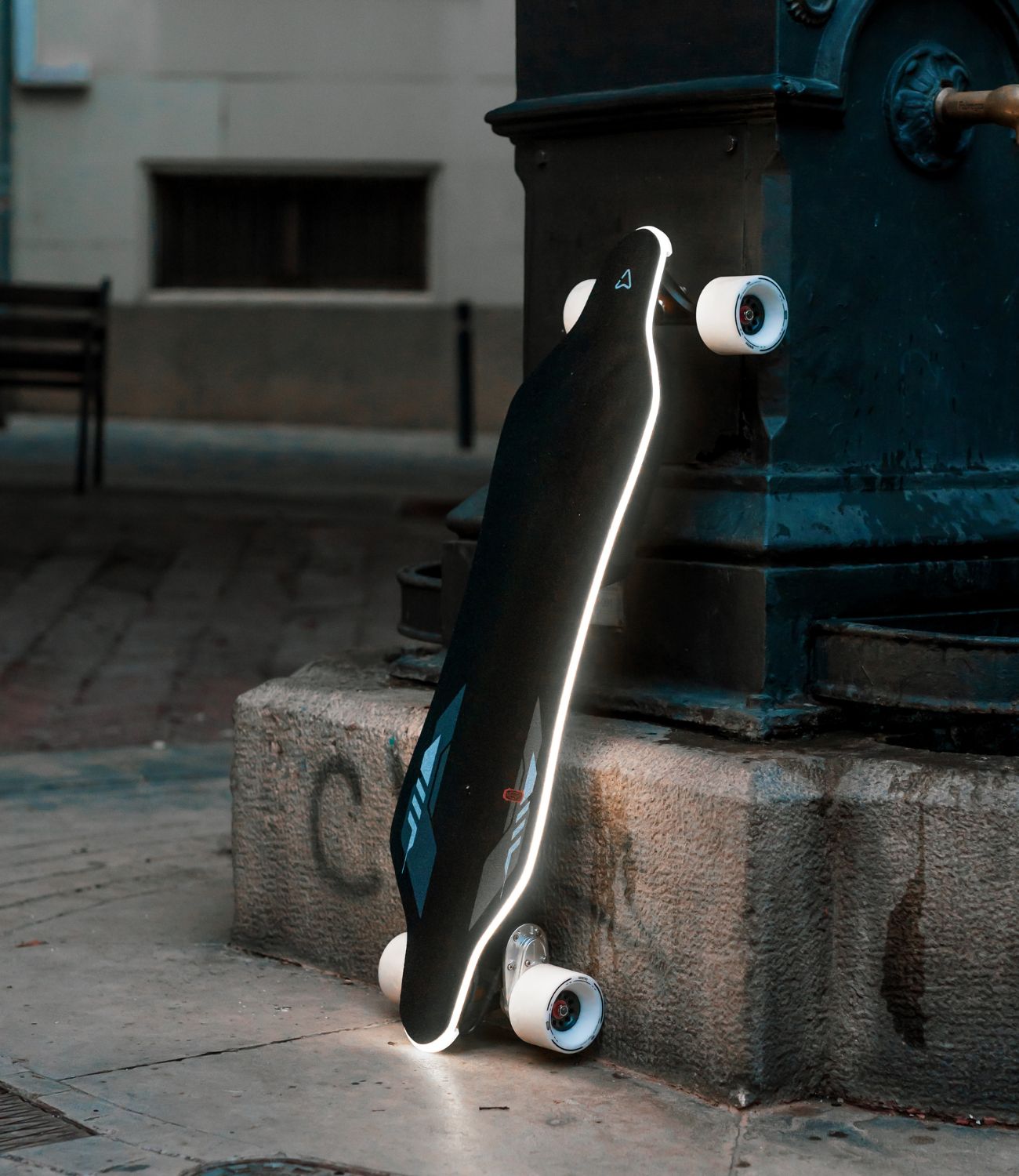 Meepo Voyager X electric skateboard illuminated by streetlight, showcasing sleek design.